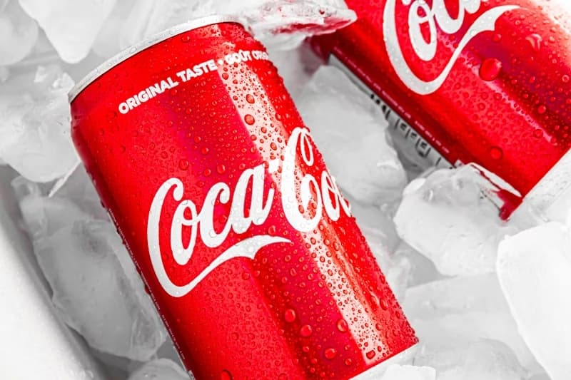 Refrescante Coca-Cola em lata cercada por gelo picado